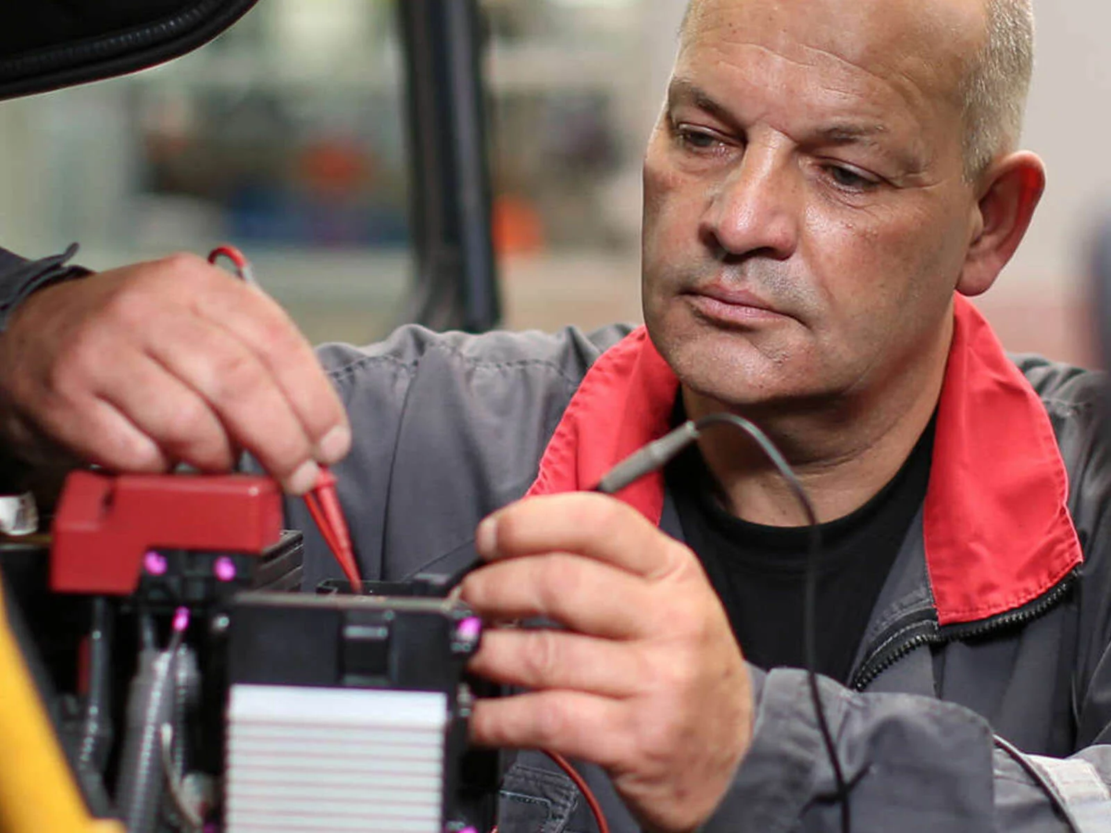 Photo of a Forklift Engineer Checking Battery Connection