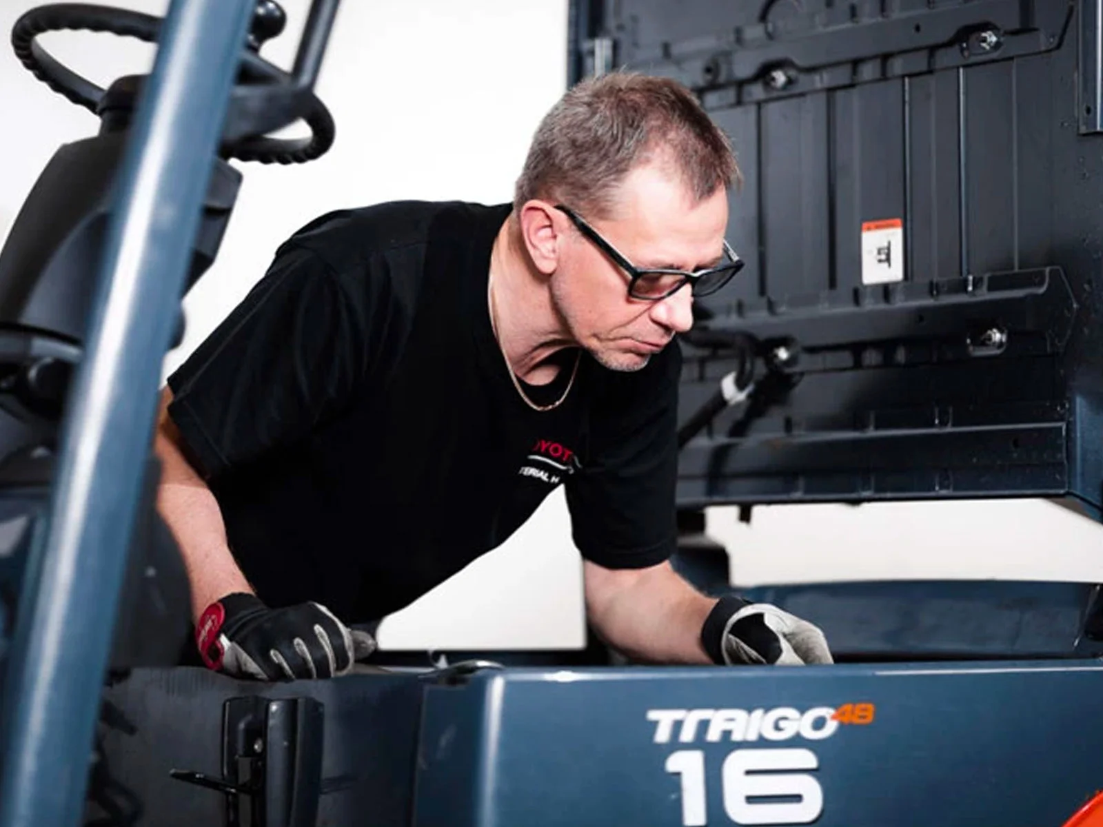 person fitting parts onto a toyota forklift truck